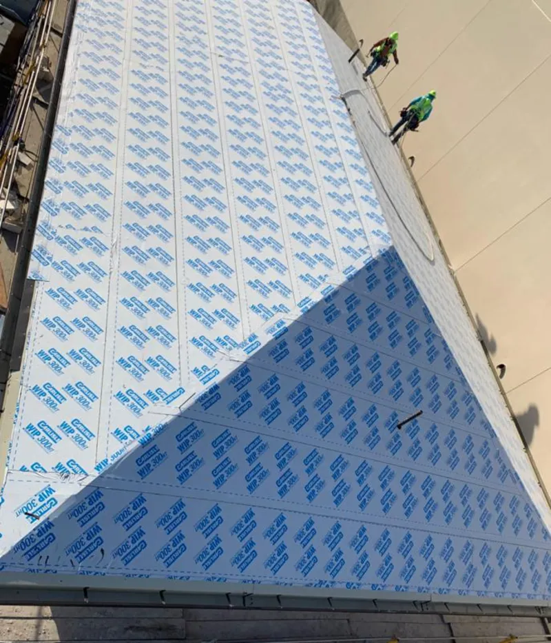 Professional roofers installing underlayment on a metal roof in Los Lunas